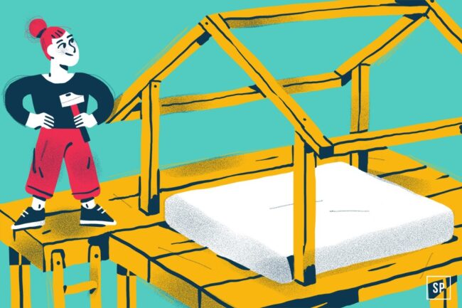 Illustration einer Person mit roten Haaren und roten Hosen, die einen Hammer in der Hand hält und selbstbewusst neben einem Massivholz-Hausrahmen mit einer weißen Matratze im Inneren steht, vor einem blaugrünen Hintergrund.