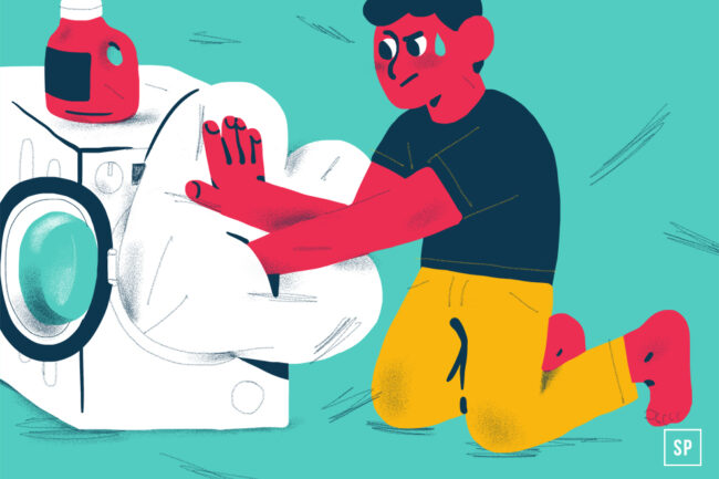 Eine illustrierte Person mit roter Haut, schwarzem Hemd und gelber Hose kniet und versucht, ein großes Kissen in eine Waschmaschine mit Frontlader zu stecken - perfekt für Tipps zum Bettdecke waschen oder Bettdecke reinigen. Obenauf steht eine Flasche mit Waschmittel.