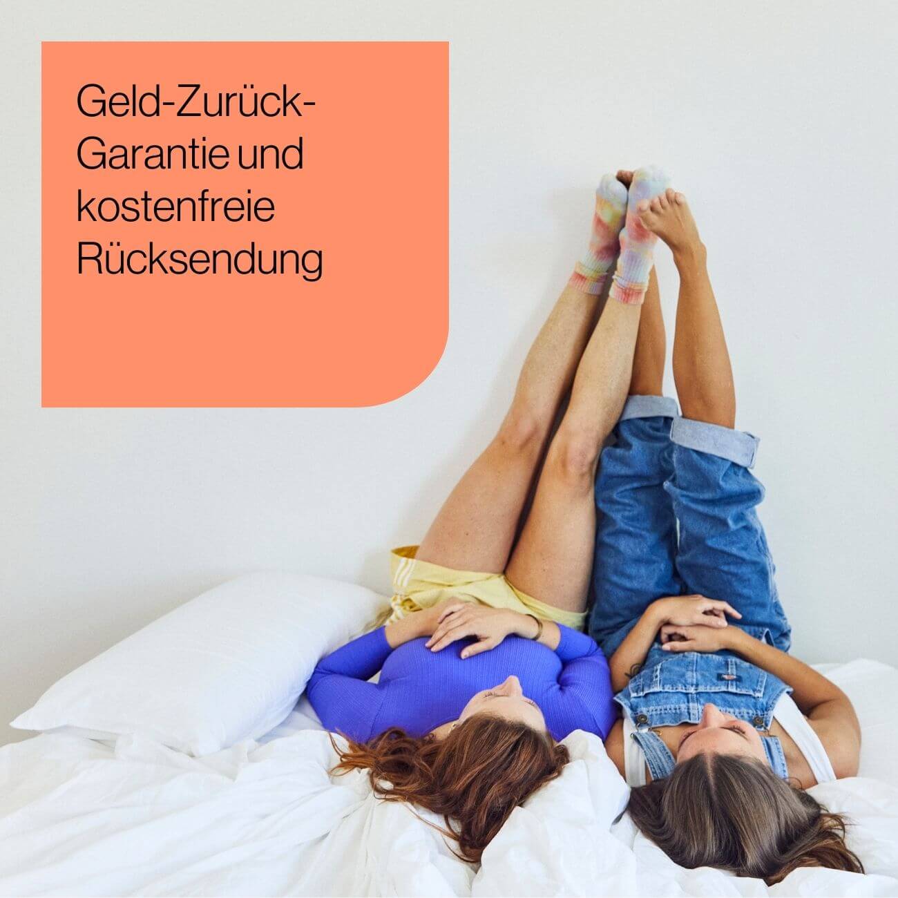 13 Zwei Personen liegen auf einem Bett und haben ihre Beine gegen eine weiße Wand gelehnt. Eine pfirsichfarbene Schachtel enthält einen deutschen Text: Geld-Zurück-Garantie und kostenfreie Rücksendung (Geld-Zurück-Garantie und kostenfreie Rücksendung).