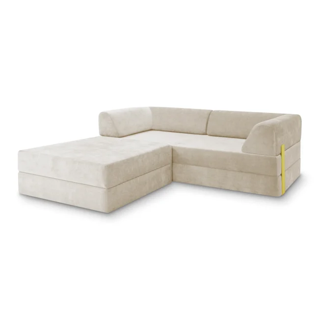 Ein modernes, hellbeiges L-förmiges Sektionssofa mit niedrigen Rückenlehnen und klaren Linien. Das Sofa hat ein minimalistisches Design und verfügt über eine Chaiselounge auf der linken Seite.