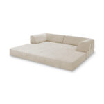 Ein großes, hellbeiges Levi Modulares Bodensofa mit niedrigen Rücken- und Seitenkissen, flacher Sitzfläche und minimalistischem Design. Das 2-Sitzer-Sofa hat Armlehnen mit kleinen Seitentaschen und steht ohne sichtbare Beine direkt auf dem Boden.