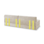 Ein beigefarbenes, gepolstertes Modulares Sofa mit modernem Design, das sechs vertikale gelbe Streifen aufweist, die gleichmäßig über die Rückenlehne verteilt sind.