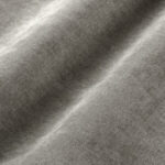 Nahaufnahme eines weichen, hellgrauen Stoffes mit sanften Wellen und Falten, die seine glatte Textur und seinen subtilen Glanz hervorheben.