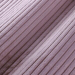 Nahaufnahme eines weichen, gerippten Stoffes in einem hellen Lavendel- oder Mauve-Ton, der parallele, strukturierte Linien und eine weiche, samtige Oberfläche aufweist.