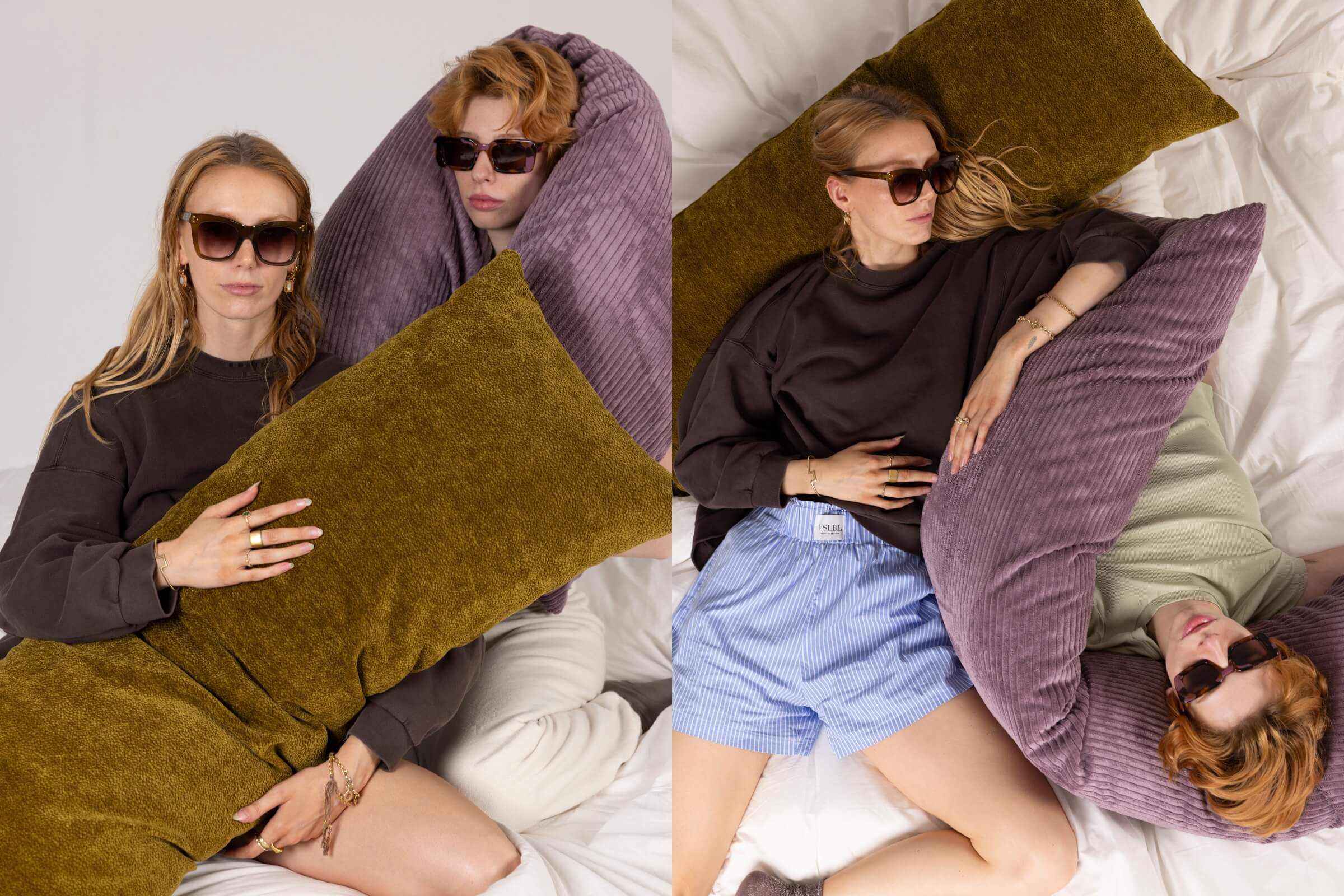 Zwei Frauen mit Sonnenbrillen entspannen sich auf einem Bett mit großen Kissen. Auf der linken Seite umarmt eine ein olivgrünes Kissen, während die andere in ein lila Kissen eingewickelt ist. Auf der rechten Seite liegen sie nebeneinander und halten die gleichen Kissen.