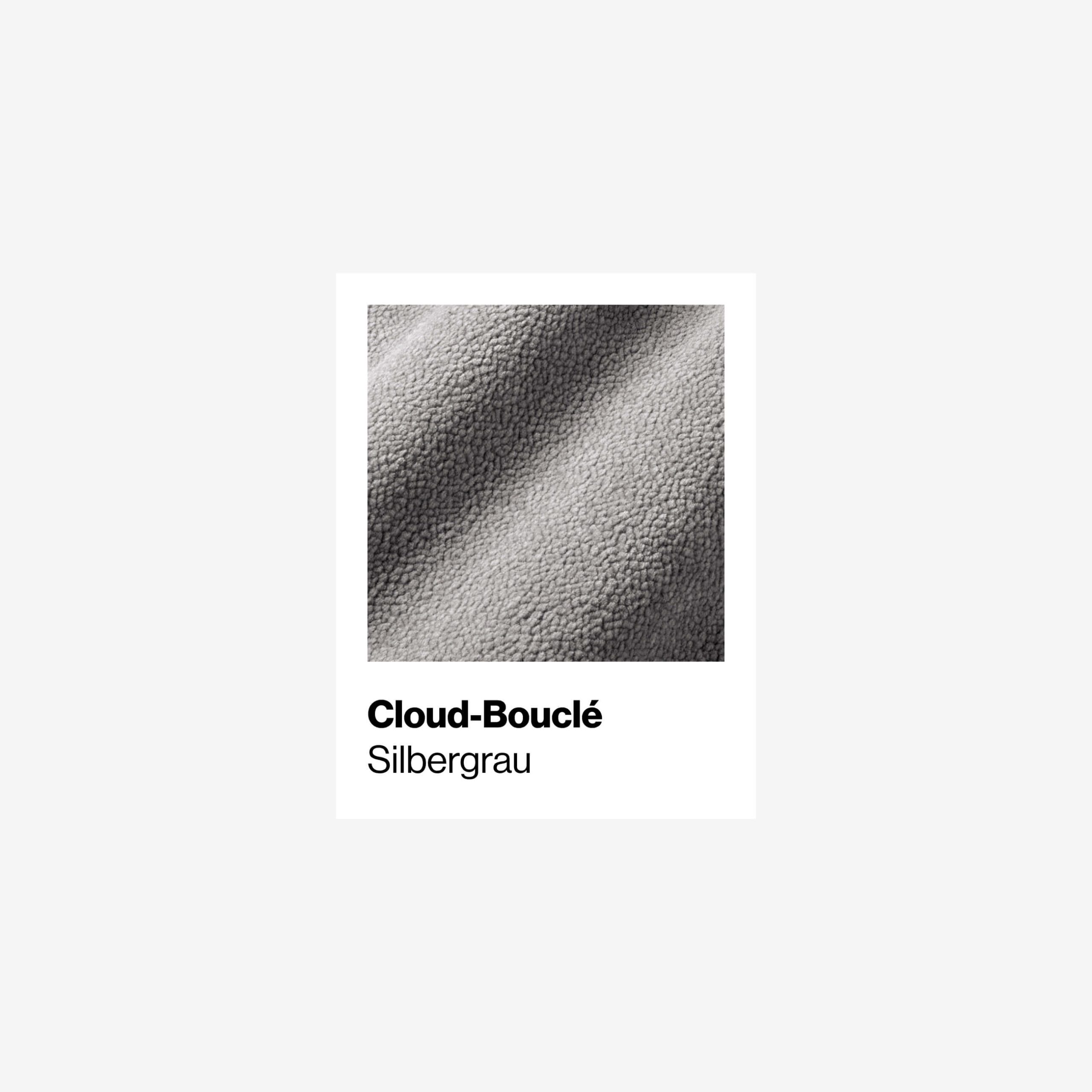 Nahaufnahme eines Cloud-Bouclé-Stoffes in einem hellen Silbergrau mit der Aufschrift Cloud-Bouclé Silbergrau auf weißem Hintergrund. Die Textur erscheint weich und leicht holprig.
