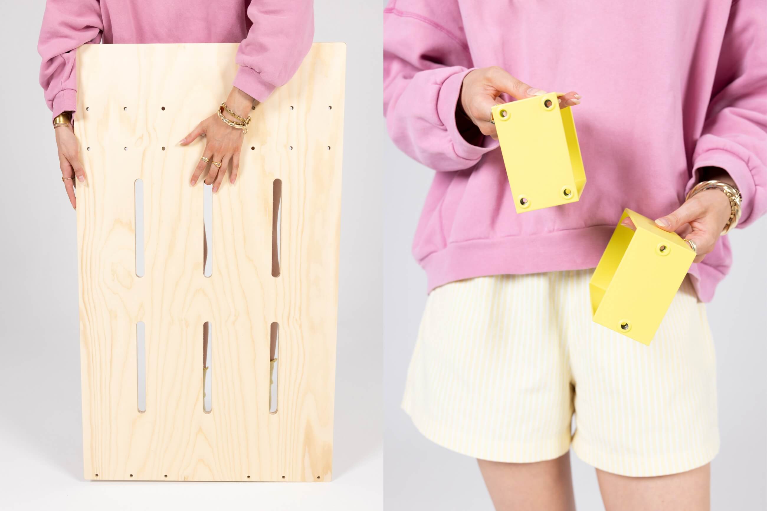 Eine Person in einem rosa Pullover und hellen Shorts hält ein großes rechteckiges Holzbrett mit vertikalen Schlitzen (links) und zwei kleine gelbe Metallklammern mit Löchern (rechts).