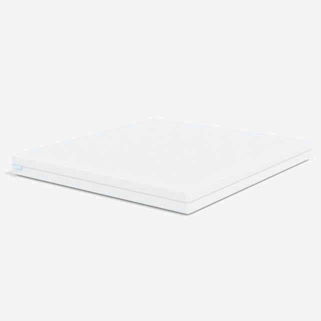 Eine schlichte, rechteckige, weiße Matratzenauflage ist auf weißem Hintergrund abgebildet, aus einem Winkel betrachtet, der ihre Dicke und ihre sauberen Kanten zeigt.