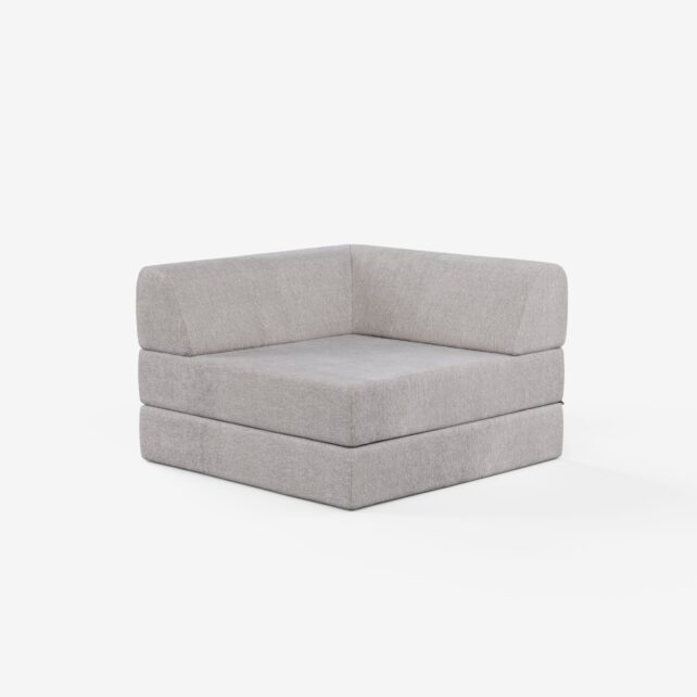 Eine moderne, hellgrau gepolsterte Eckbank mit dicken, rechteckigen Kissen und minimalistischem Design vor einem schlichten weißen Hintergrund.