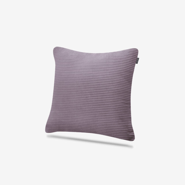 Ein quadratisches, geripptes lavendelfarbenes Kissen mit weicher Textur, das vor einem schlichten weißen Hintergrund gezeigt wird.