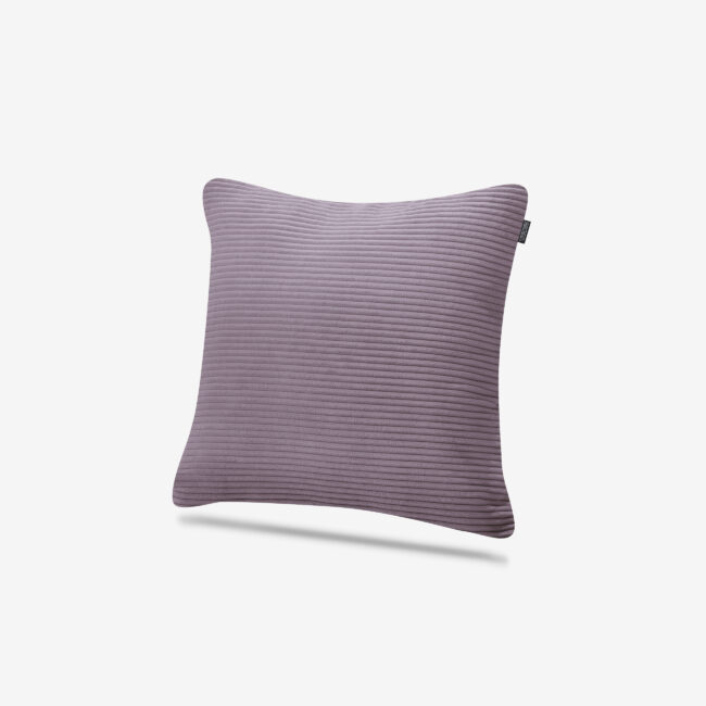 Ein quadratisches, geripptes lavendelfarbenes Kissen mit weicher Textur, das vor einem schlichten weißen Hintergrund gezeigt wird.