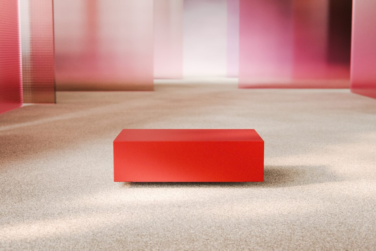 Auf einem hellen, mit Teppich ausgelegten Boden steht eine rote, rechteckige Bank, umgeben von durchscheinenden rosa und violetten Paneelen in einem minimalistischen, modernen Raum.