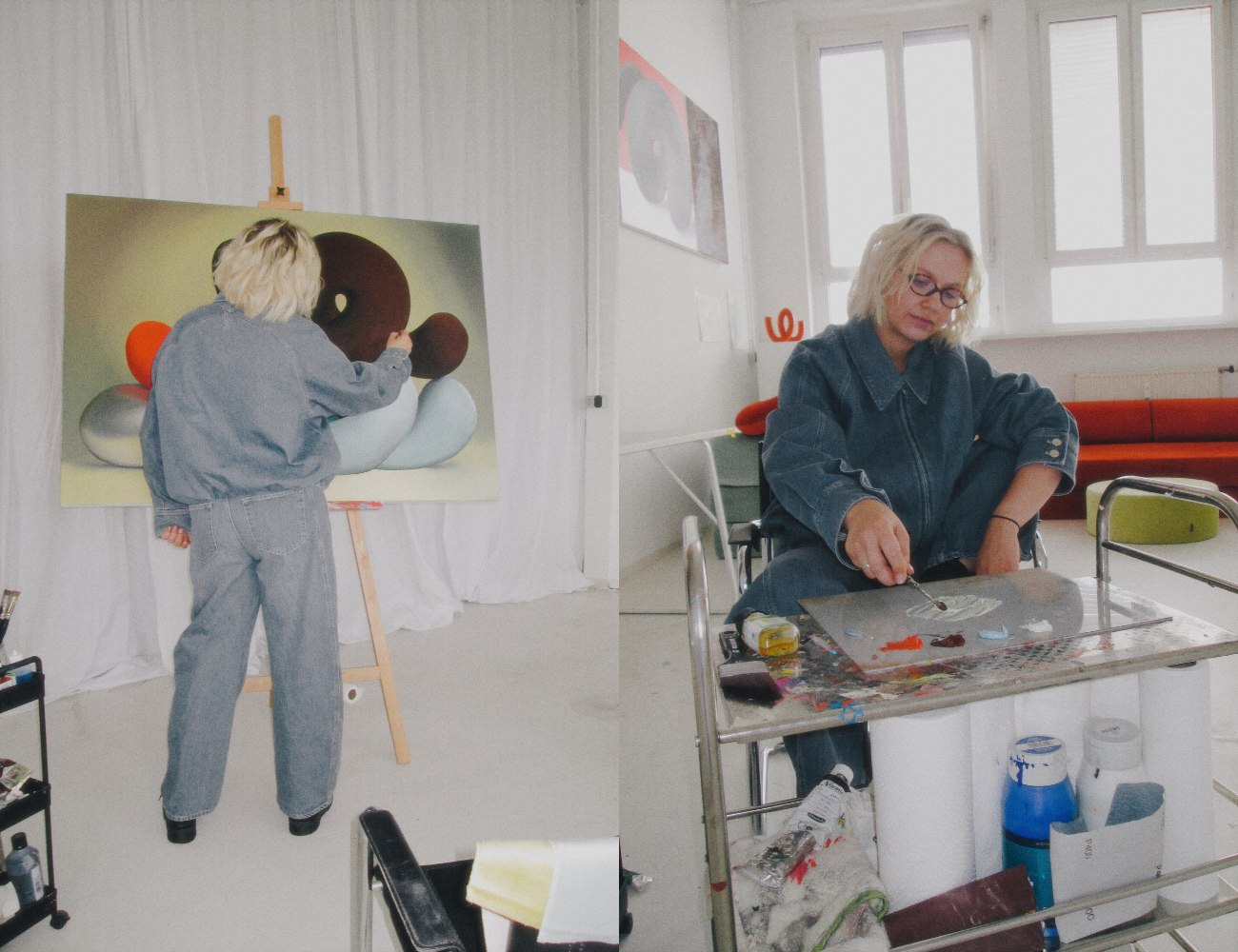Ju Schnee, die ein Jeansoutfit trägt, malt im Rahmen einer Zusammenarbeit mit dem Snooze Project auf einer großen Leinwand und mischt Farben auf einer Palette.